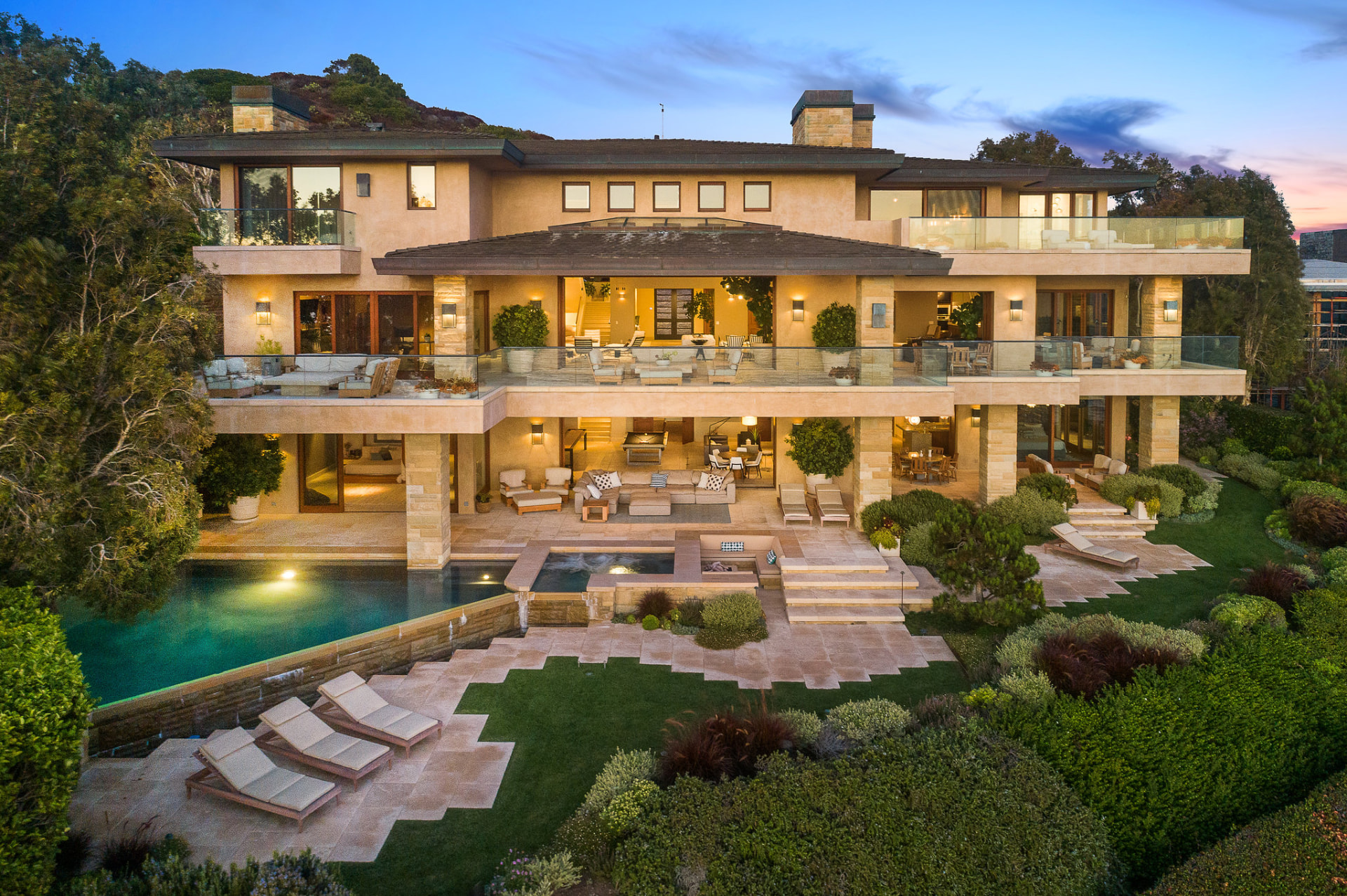 Hillside estate with terraced patios and pool at dusk