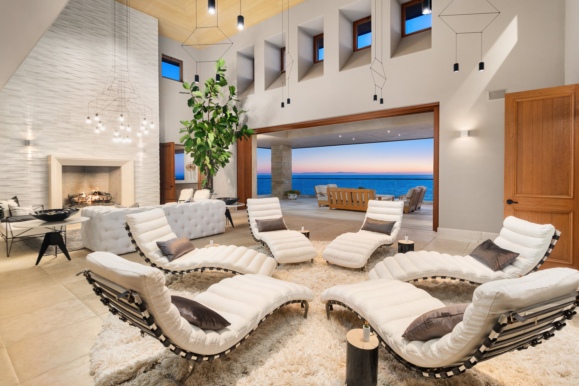 Bright lounge with white chaises and an ocean-view patio