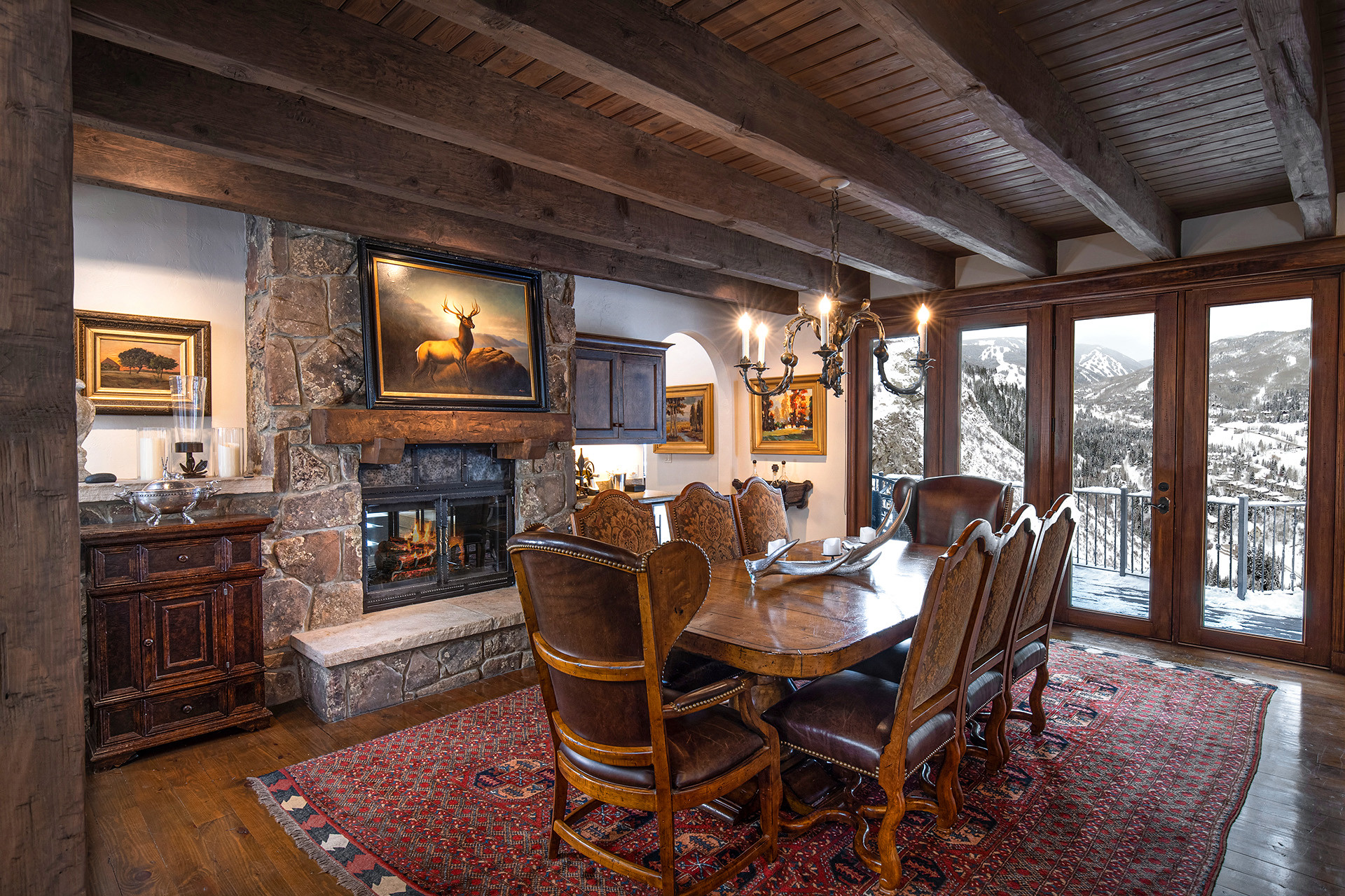 Rustic dining room with stone fireplace and mountain views