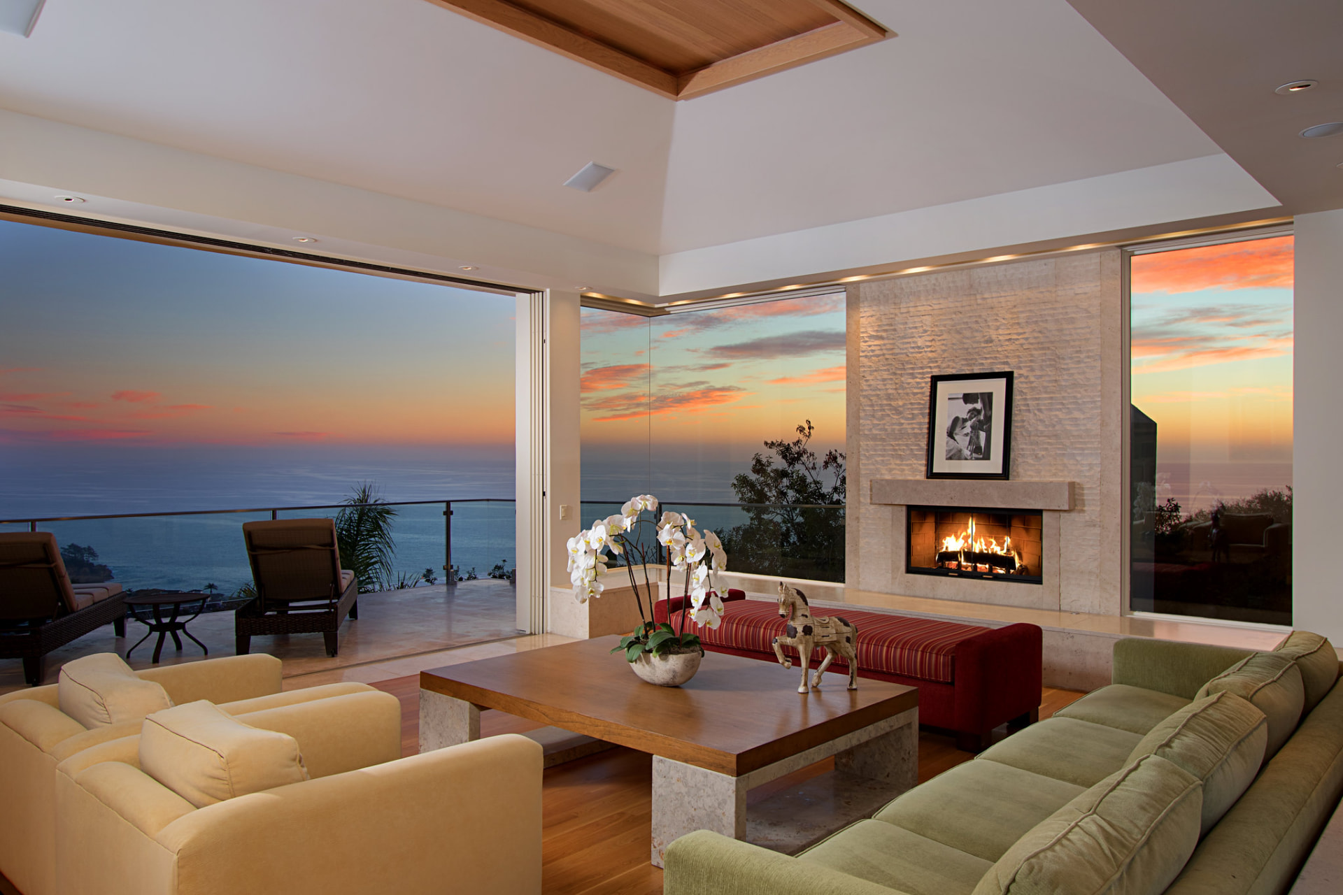 Living room with fireplace and ocean sunset views