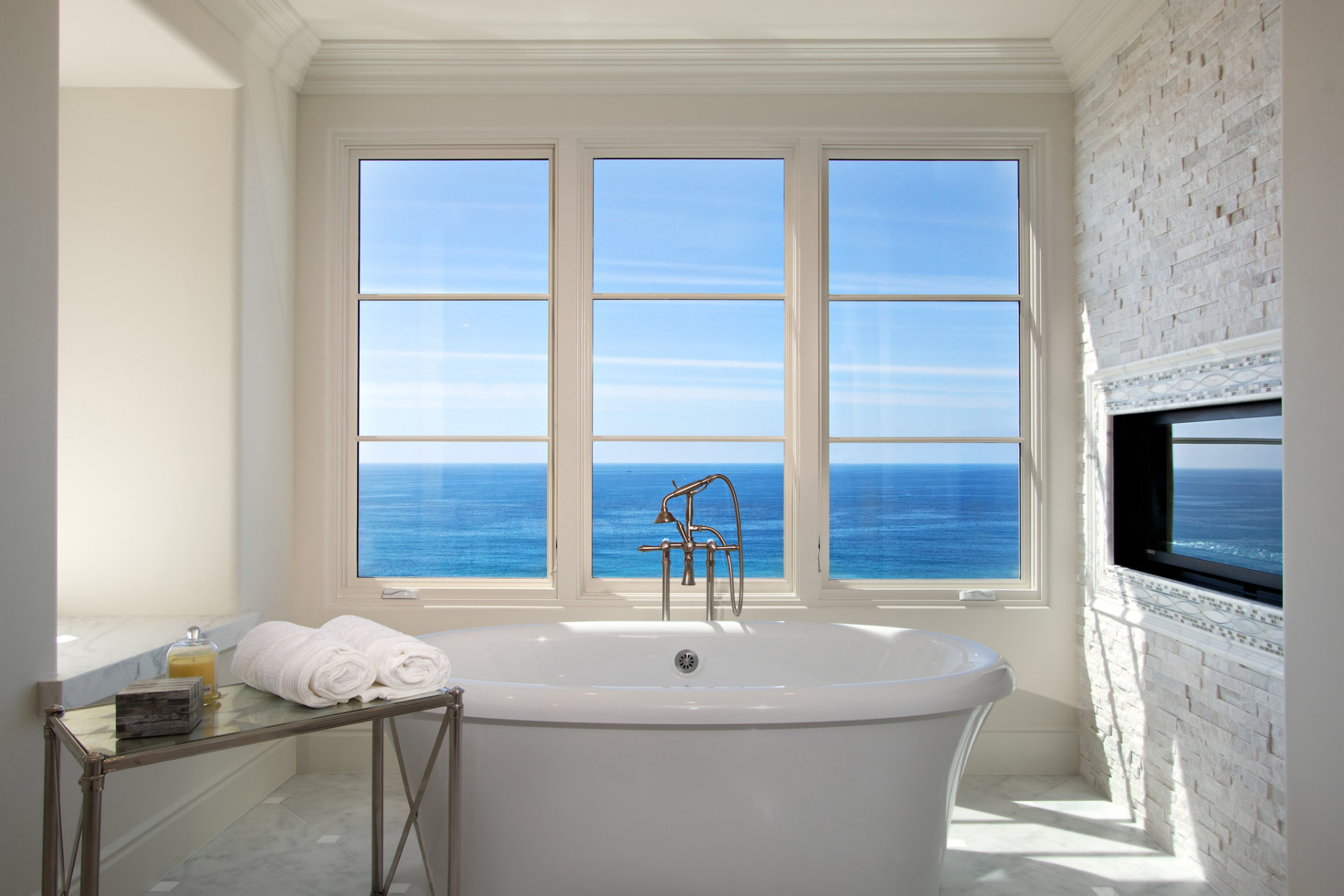 Soaking tub before a wide ocean-view window