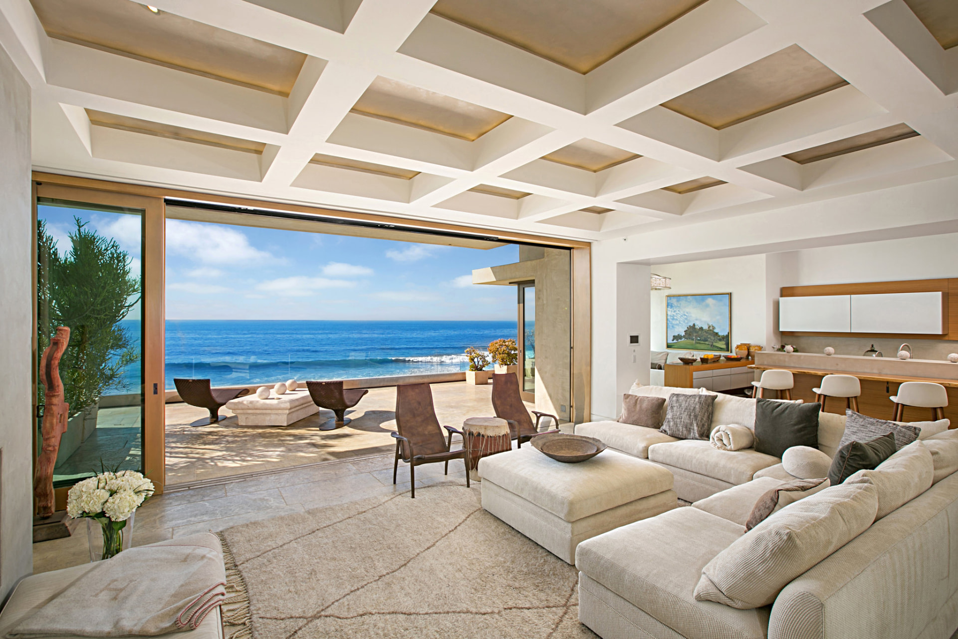 Oceanfront living room opening onto a sunny terrace