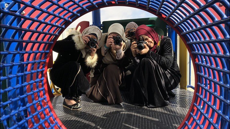 Young refugee women learning photography on the 2018 mission trip
